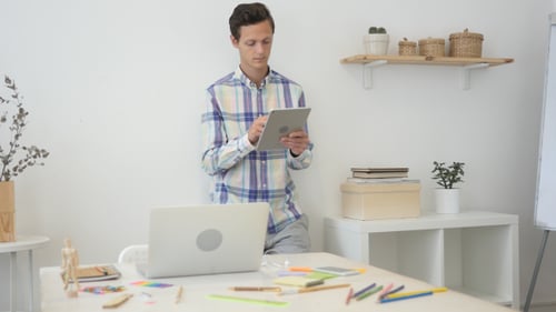 Busy Using Tablet while Standing in Creative Office