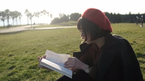 Woman Reading Book Outdoors in a Park