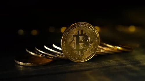 Handful of Bitcoins Stacked on Top of Each Other on a Table One Stands on an Edge of a Black Gold