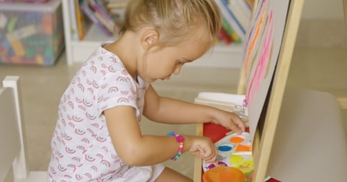 Cute Little Girl Mixing Paints For Her Painting