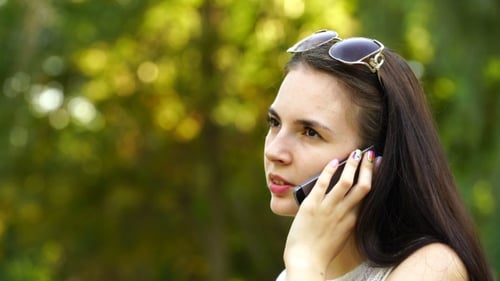 Young Woman Talking on Cell Phone in Park
