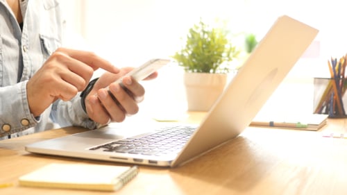 Person Using Smartphone in Modern Workspace