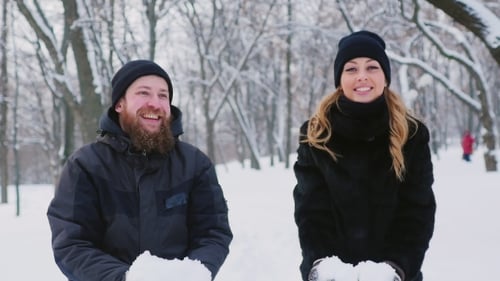 Un jeune couple déménage dans la forêt d'hiver, jette de la neige