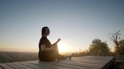 Woman Practices Yoga At Sunrise Overlooking City