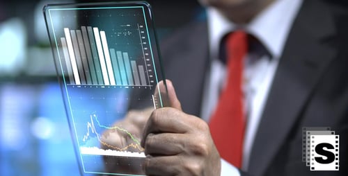 Executive Analyzing Data on Futuristic Transparent Tablet