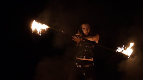 Woman Performing Fiery Fire Dance with Baton