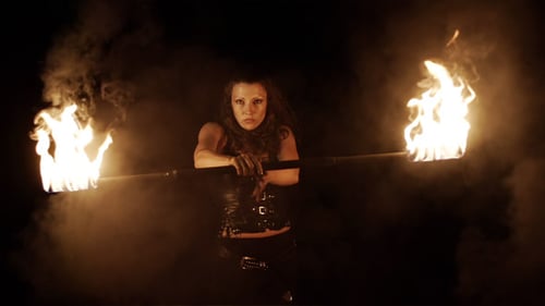 Woman with Fire Stick Performing in the Dark