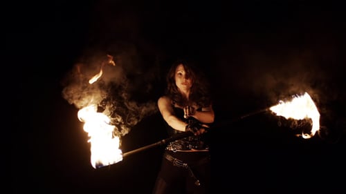 Woman Fire Dancer Performance on Dark Background
