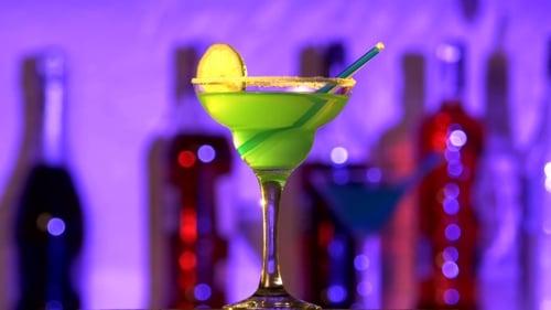 Grüner und gelber Cocktail mit Zitronendekor und Kokosnuss am Rand