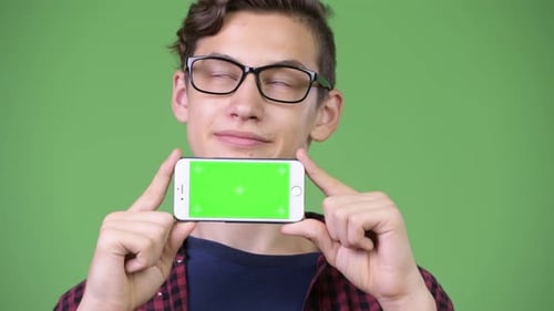 Young Adult Holding Smartphone with Green Screen Display