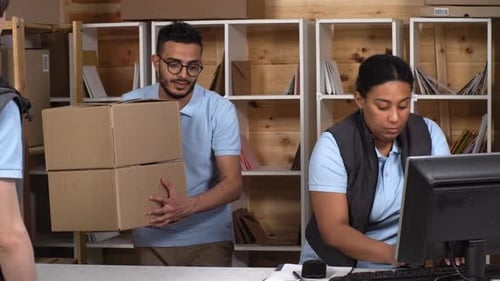 Multiethnic Post Office Clerks Giving Boxes to Courier