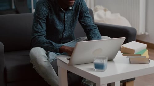 Man Working on Laptop at Home on Couch