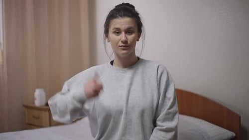 Woman Gives Thumbs Up in Bedroom