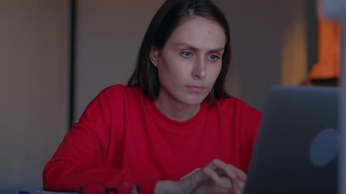 Worried Woman Working on Laptop Computer at Home