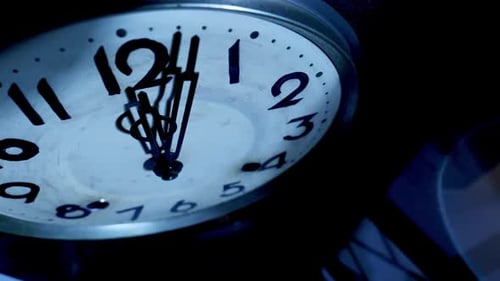 Close up of antique pendulum wall clock on midnight