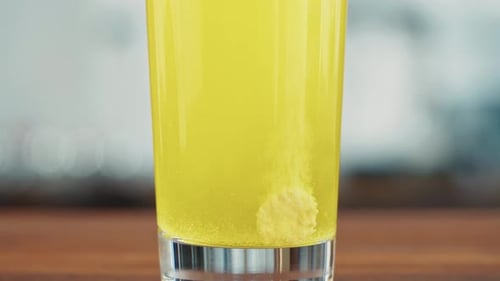 Effervescent Tablet Dissolving in Bright Yellow Liquid