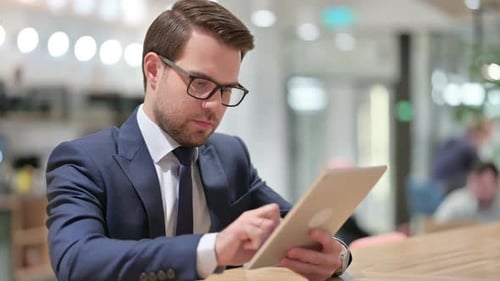 Businessman Working on Tablet Device in Workplace