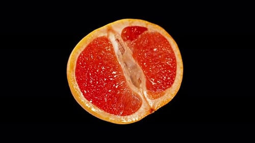Rote Grapefruit in zwei Teile geschnitten auf schwarzem Hintergrund