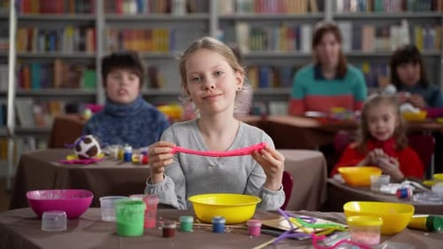 Girl Making Pink Craft in Library Classroom