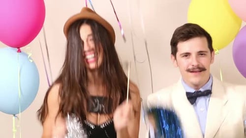 Party couple dancing and holding in love boards in photo booth