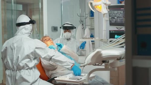 Dentist Treating Patient in Protective Gear