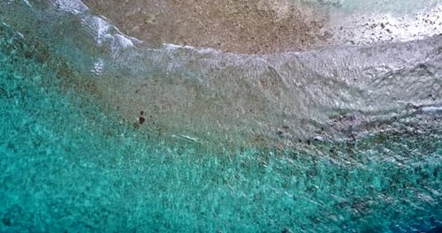 Tropical birds eye clean view of a sunshine white sandy paradise beach and aqua blue ocean backgroun