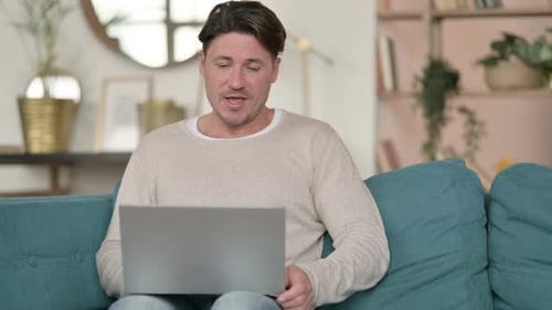 Adult Man Video Calling on Laptop at Home