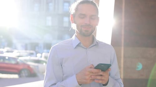 Business Man Using Mobile Phone Outdoors On Sunny Day At Street