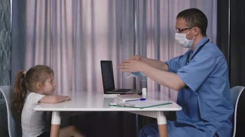 Doctor Putting Mask on Little Girl Patient