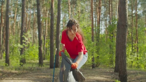Voluntario asiático con bolsa de basura limpiando la naturaleza