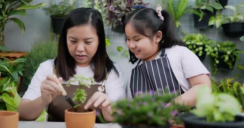 Mother teaching daughter to plant trees