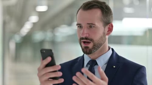 Man Celebrates Good News on Mobile Phone