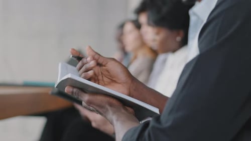 Attentive Professionals Taking Notes During Corporate Meeting