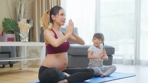 Pregnant Woman and Daughter Doing Yoga at Home