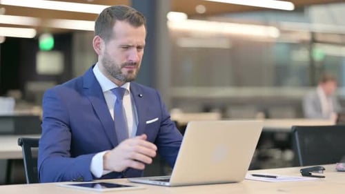 Frustrated Businessman Reacting to Computer Problems in Office