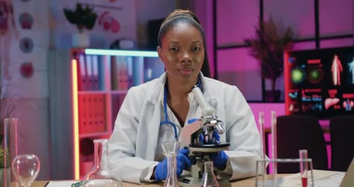 Smiling Scientist in a Lab with Microscope