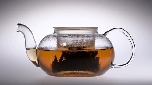 Tea Is Brewed in a Glass Teapot. Slow Motion. Studio