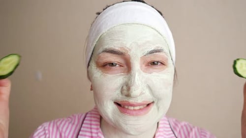 Woman With Face Mask and Cucumber Slices