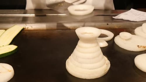 Chef Stacks Onion Rings on Flattop Grill