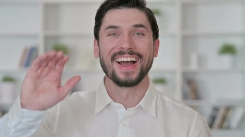 Cheerful Young Businessman Waving Hello