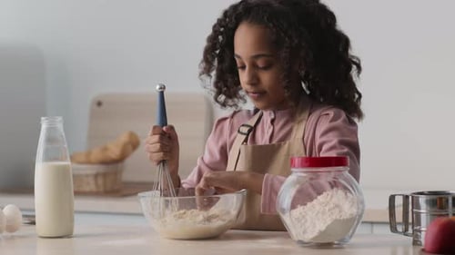Girl Mixing Dough in Bowl in Bright Kitchen