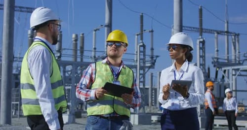 Engineers Inspecting Power Station on Sunny Day