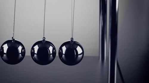 Die Kugeln einer Newtons Cradle kollidieren in Zeitlupe