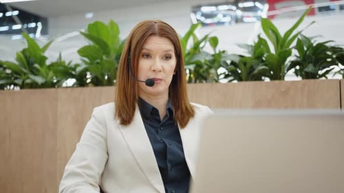 Woman in Blazer on Video Call in Modern Office
