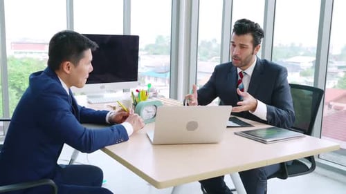 Two Business People Talk Project Strategy at Office
