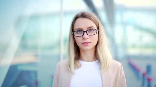 Close up portrait young blonde business woman with glasses looking at camera smiling