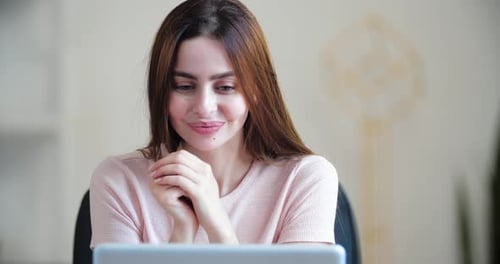 Excited Woman Celebrating Success with Laptop Indoors