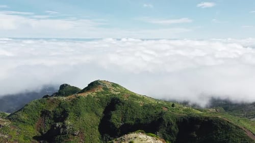 Aerial View of Green Mountain Above Clouds