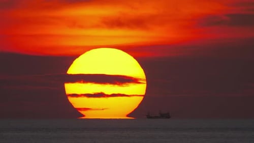 Fiery Sunset Over the Ocean with Silhouette Boat