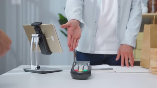 Close up hands of young man use credit card pay for vase goods order.